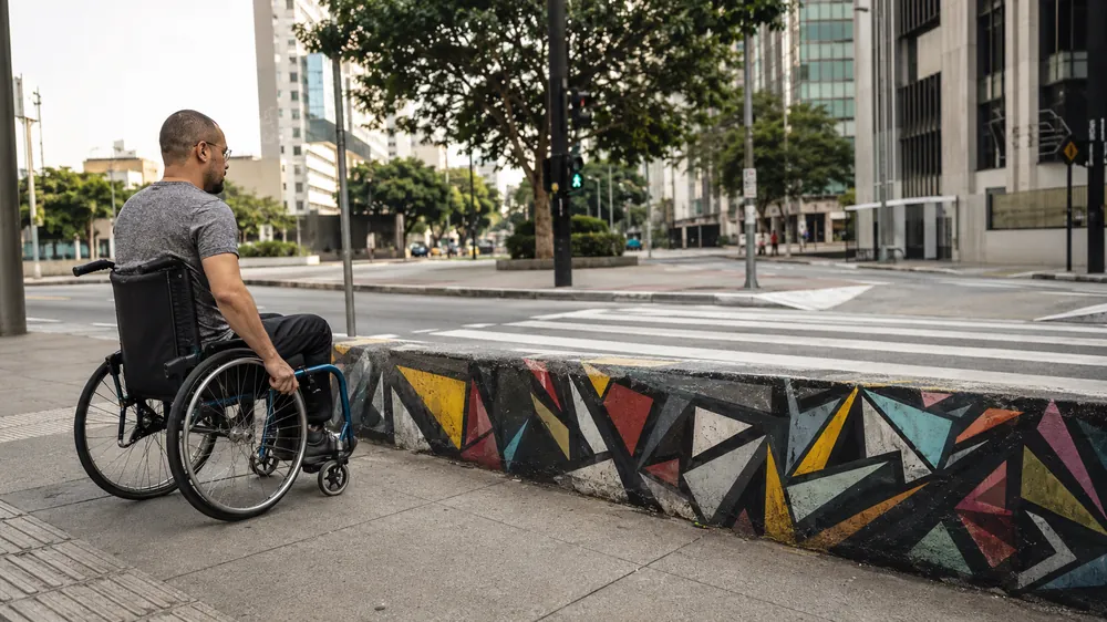 Grafite chamando atenção para a falta de rampas de acesso em calçada de São Paulo